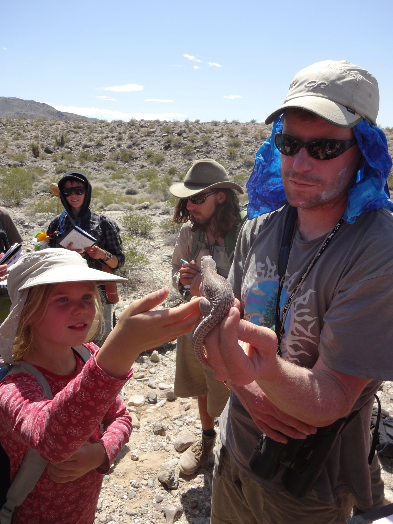 chris lay holding a desert iguana
